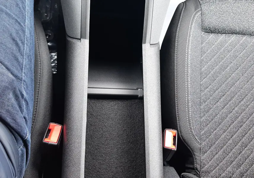 Vue plongeante sur la console centrale noire et les sièges tissu gris du Peugeot Rifter Bleu Kiama 2026.
