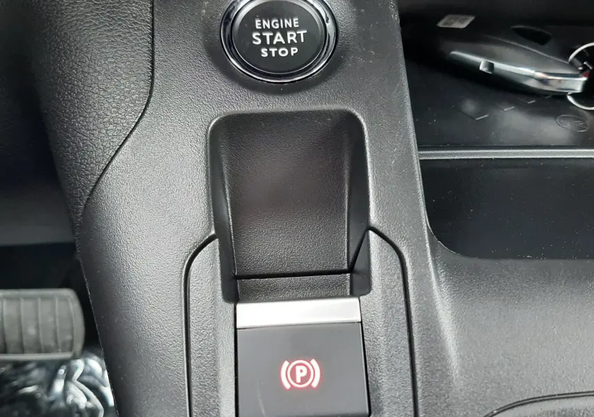 Gros plan sur la console centrale du Peugeot Rifter bleu Kiama, montrant le bouton start/stop et le frein à main électronique.