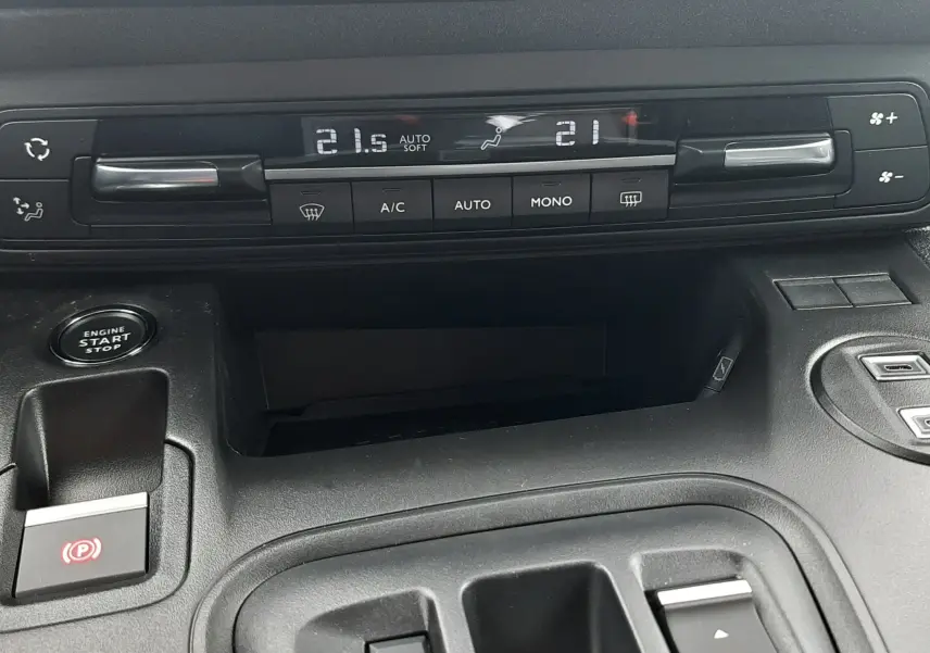 Vue rapprochée de la console centrale du Peugeot Rifter bleu Kiama, montrant les commandes de climatisation et la boîte automatique.