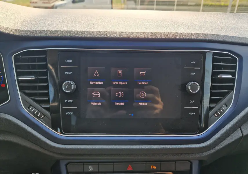 Vue rapprochée de l'écran tactile central du Volkswagen T-Roc gris foncé 2021, affichant le menu principal multimédia.