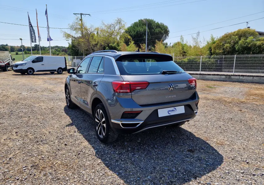 Volkswagen T-Roc gris foncé métal, vue 3/4 arrière droit, avec jantes alliage et toit noir contrasté.