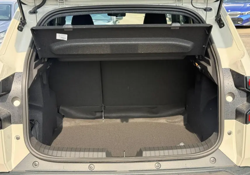 Vue arrière du coffre ouvert d'un Dacia Duster blanc Glacier 2026, montrant l'espace de chargement vide.