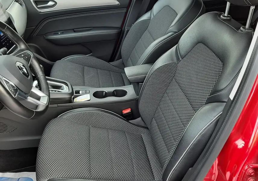 Vue intérieure côté conducteur du Renault Arkana rouge Flame 2021, sièges noirs en tissu et cuir avec console centrale visible.