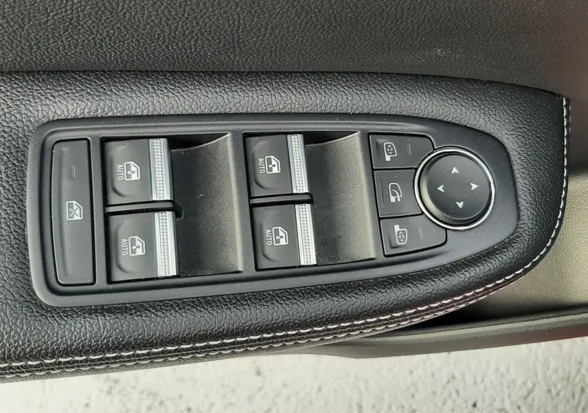 Panneau de commandes des vitres et rétroviseurs en cuir noir avec surpiqûres blanches dans une Renault Arkana rouge Flame 2021.