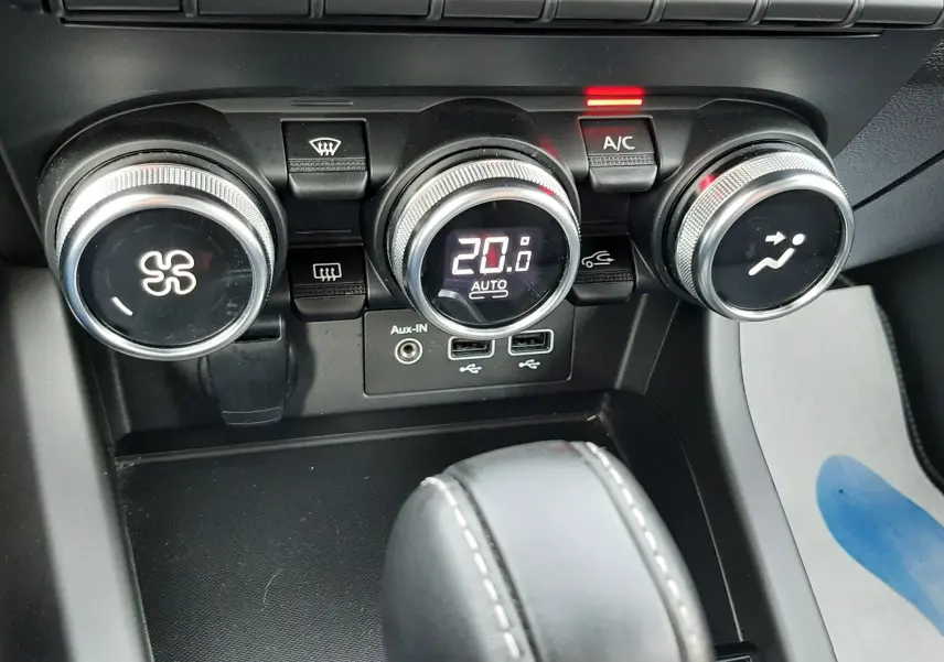 Gros plan sur les commandes de climatisation et la console centrale du Renault Arkana rouge Flame 2021, version Intens.