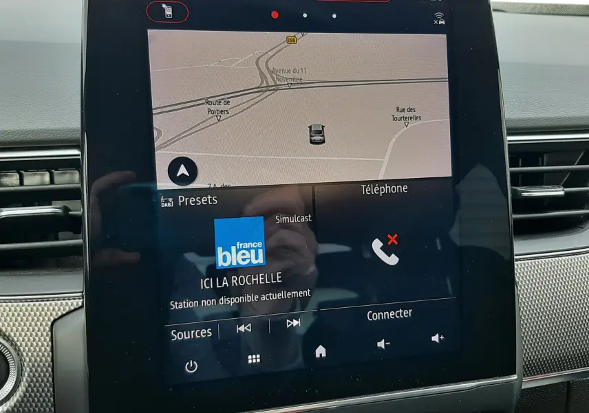 Écran tactile central du Renault Arkana rouge Flame 2021 affichant navigation et radio France Bleu