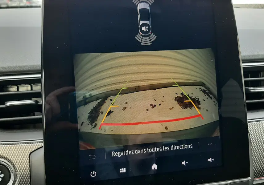 Écran central de Renault Arkana 2021 montrant la caméra de recul avec lignes de guidage et alertes de proximité.