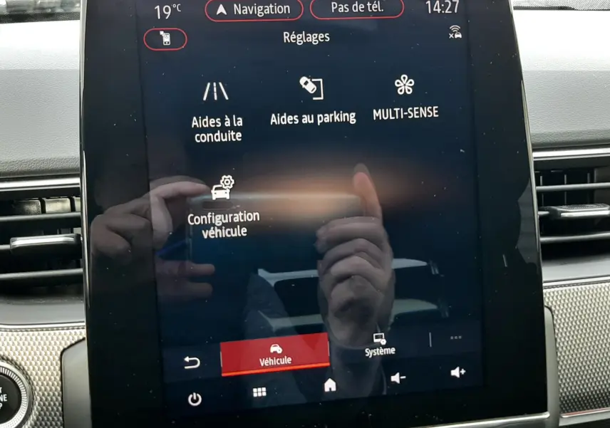 Écran tactile central du tableau de bord du Renault Arkana 1.6 E-TECH 145 Intens affichant les réglages d'aides à la conduite et de configuration véhicule.