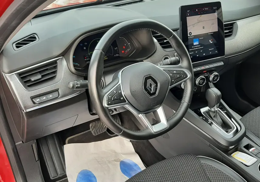 Intérieur du Renault Arkana rouge Flame 2021, vue côté conducteur sur le tableau de bord et la console centrale avec écran tactile.