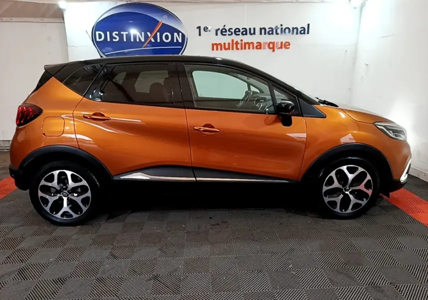Profil côté gauche d'un Renault Captur Intens TCe 150 orange, avec toit noir et jantes alliage distinctives.