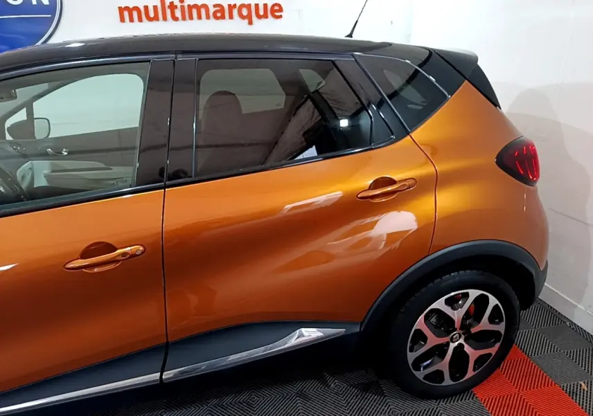 Profil côté droit du Renault Captur Intens orange 2019 avec toit noir et jantes alliage distinctives.