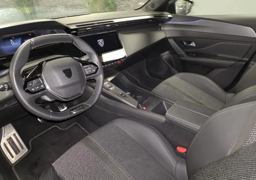 Intérieur avant de la Peugeot 408 noir, vue côté conducteur avec volant cuir perforé et écran tactile central.