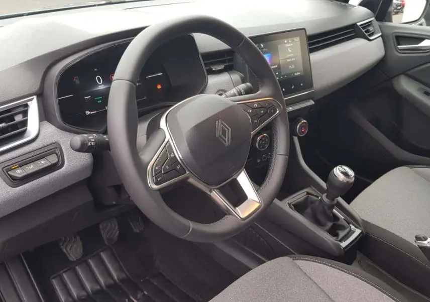 Vue intérieure côté conducteur de la Renault Clio V dCi 100 Evolution 2025, volant multifonction et boîte manuelle visibles.