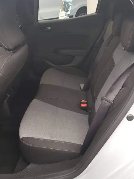 Vue intérieure arrière droite de la Renault Clio gris 2025, montrant les sièges arrière en tissu bicolore et la ceinture centrale 3 points.