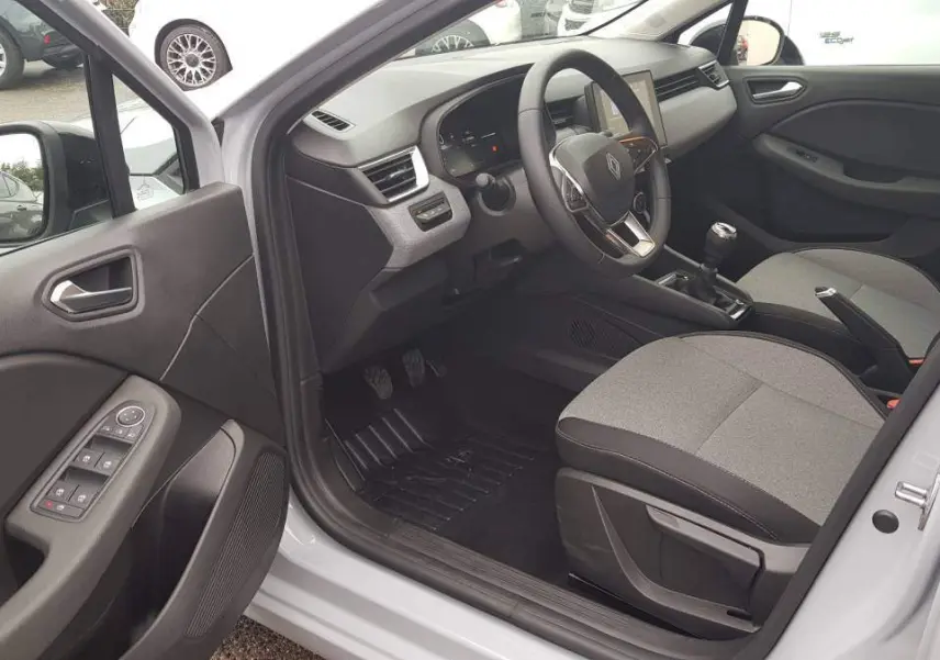 Intérieur côté conducteur d'une Renault Clio gris 2025, avec tableau de bord moderne et boîte manuelle visible.