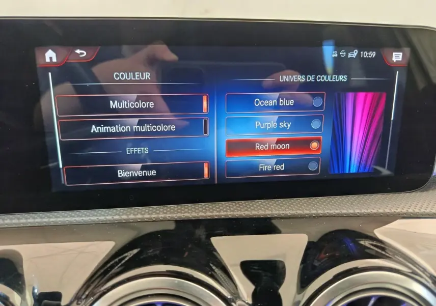 Écran tactile central de la Mercedes Classe A 250 e AMG Line 2021 affichant les options de couleurs d'ambiance intérieure.