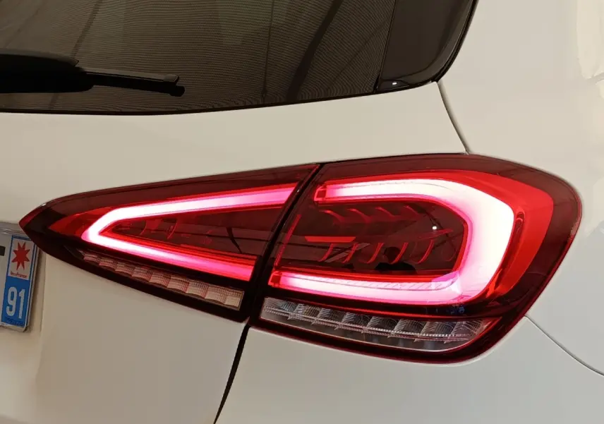 Gros plan sur le feu arrière droit allumé d'une Mercedes Classe A 250 e AMG Line blanche de 2021.