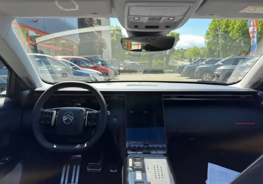 Vue intérieure avant du Citroën C5 Aircross 2026, tableau de bord noir avec grand écran tactile central et volant multifonctions.