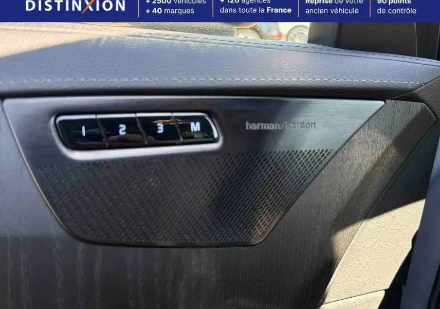 Détail intérieur montrant la porte côté conducteur du Volvo XC90 gris avec haut-parleur Harman Kardon et commandes mémoire sièges.