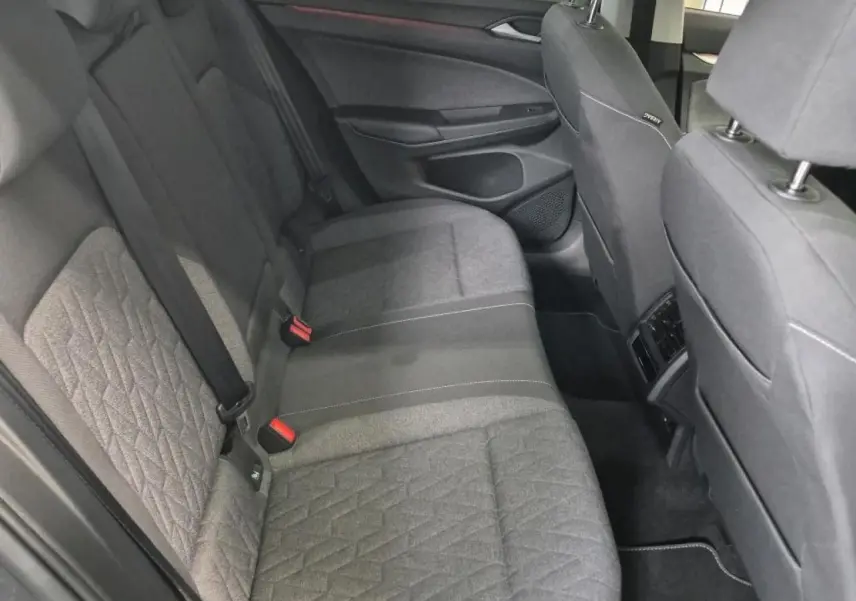 Vue côté droit de la banquette arrière grise de la Volkswagen Golf 8 avec ceintures de sécurité et appuis-tête.