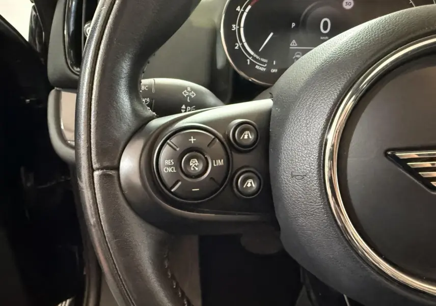 Gros plan sur le volant cuir noir de la MINI Countryman 2020 avec commandes de régulateur de vitesse visibles côté gauche.