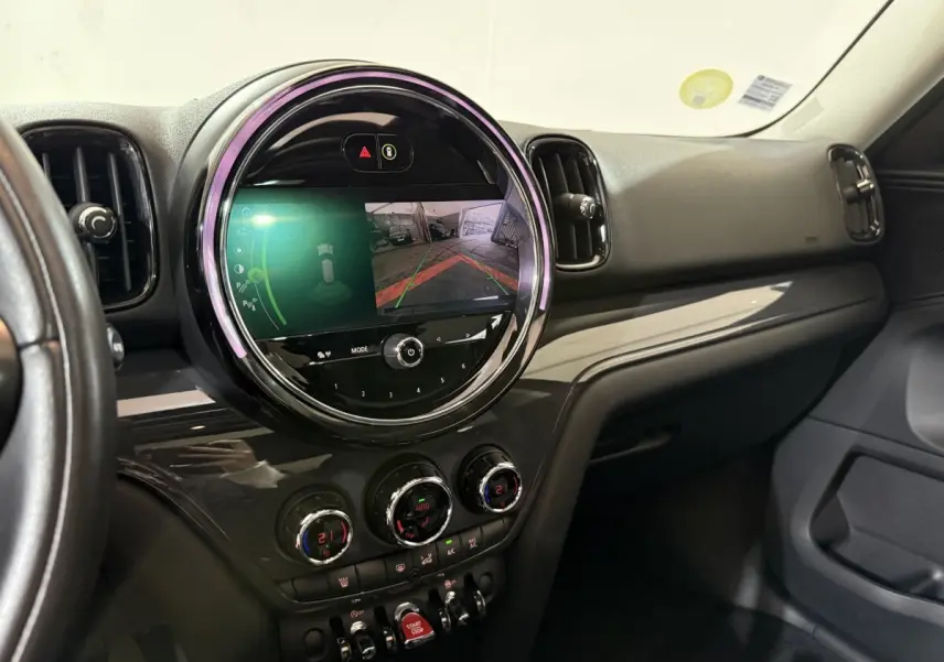 Vue intérieure du tableau de bord noir du MINI COUNTRYMAN 2020 avec écran tactile circulaire affichant la caméra de recul.