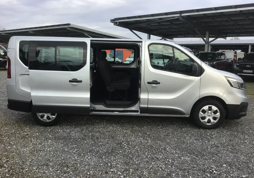 Vue latérale droite d’un Renault Trafic Combi gris Highland 2022 avec porte coulissante ouverte et sièges visibles.