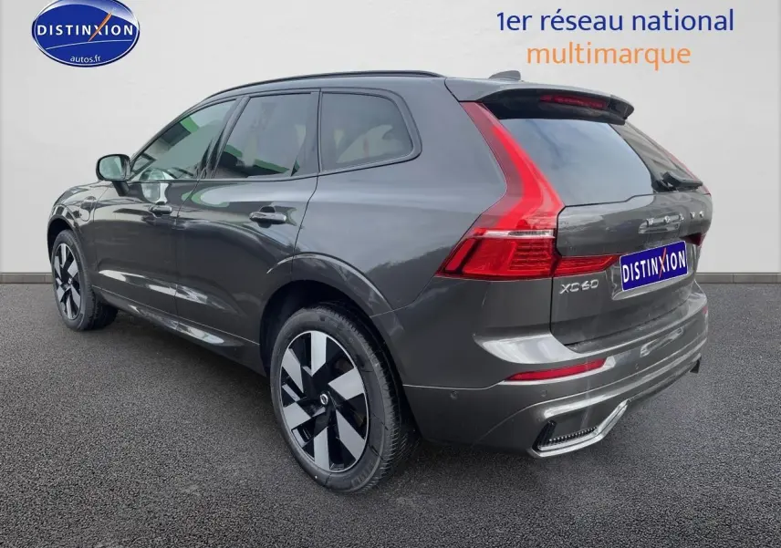Vue 3/4 arrière droite d’un Volvo XC60 gris métallisé avec feux arrière LED et jantes alliage distinctives.