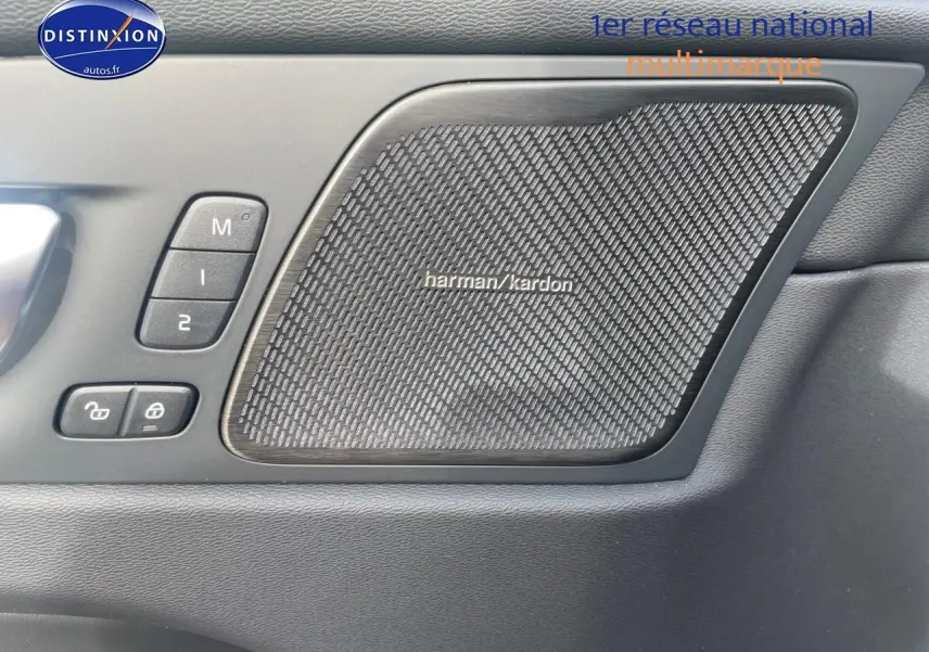Gros plan sur la porte intérieure côté gauche du Volvo XC60 gris, avec haut-parleur Harman Kardon et commandes mémoire sièges.