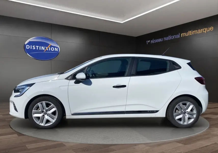 Profil côté gauche d'une Renault Clio V blanche, version E-TECH 140 Business, sur fond intérieur showroom.