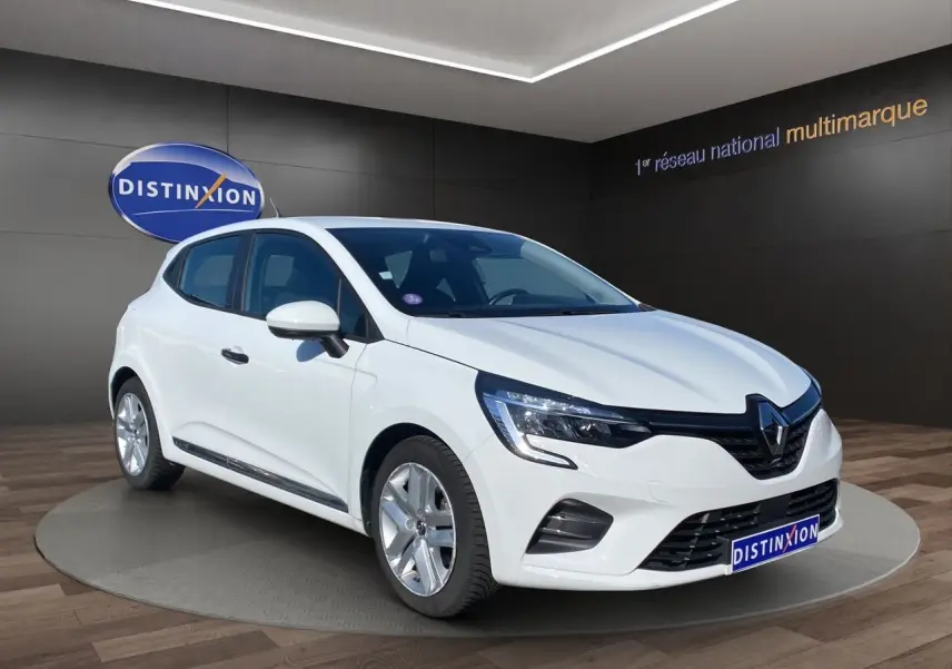 Renault Clio V E-Tech blanc en 3/4 avant droit, avec calandre noire et jantes alliage visibles en showroom.