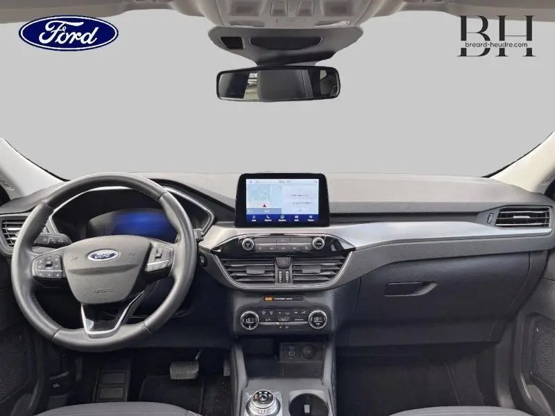 Vue intérieure frontale du tableau de bord noir du Ford Kuga 2022 avec écran tactile et volant multifonction.