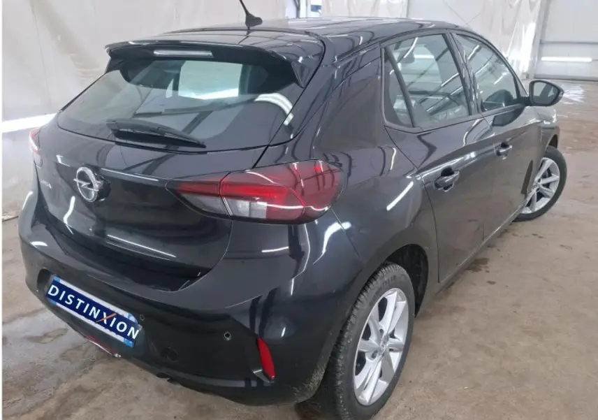 Vue 3/4 arrière droite de l’Opel Corsa F Elegance Business 2023 en noir perla avec jantes alliage et toit spoiler.