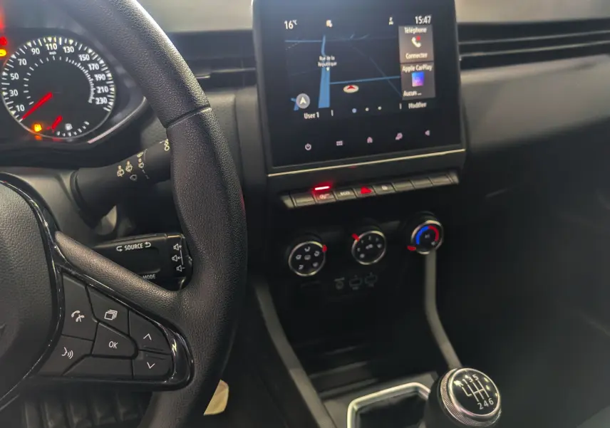 Vue intérieure de la Renault Clio V SOCIETE 2020 montrant le volant, l’écran tactile avec navigation et la boîte manuelle.