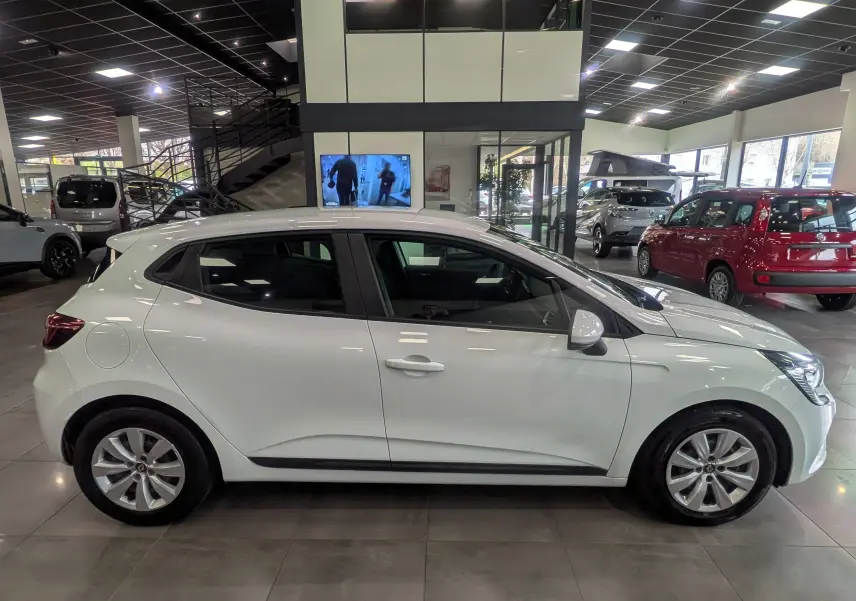 Profil côté gauche d'une Renault Clio V Blanc Glacier 2020 en version Société diesel, exposée en showroom lumineux.
