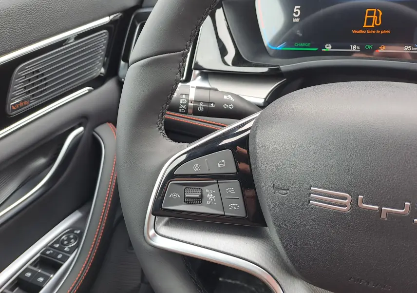 Gros plan sur le volant noir du BYD SEAL U 2025 avec commandes multifonctions et tableau de bord numérique partiel.