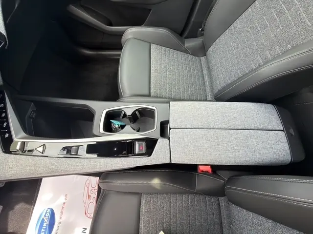 Vue rapprochée de l’intérieur avant droit du Peugeot 3008 bleu 2025, montrant la console centrale et les sièges tissu et cuir.