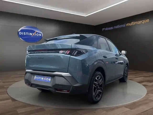 Vue 3/4 arrière droite d’un Peugeot 3008 bleu 2025 avec feux LED et jantes noires en showroom.