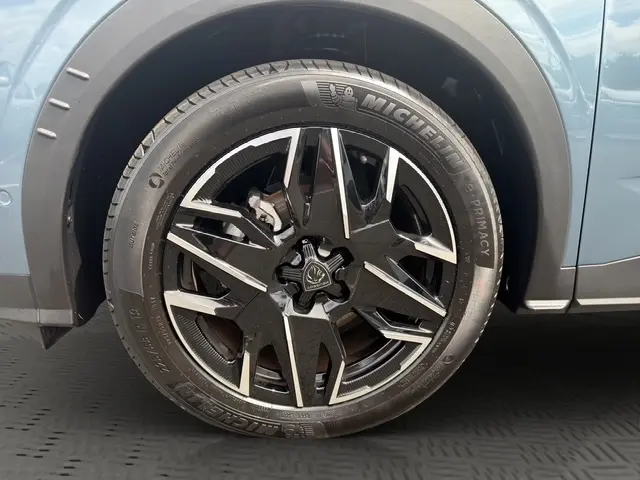 Gros plan sur la roue avant gauche du Peugeot 3008 bleu 2025 avec jante alliage noire et détails argentés.
