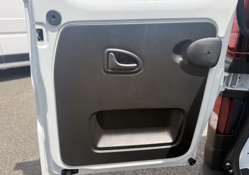 Gros plan sur la porte arrière droite blanche du Renault Trafic Fourgon avec poignée et panneau noir intérieur.