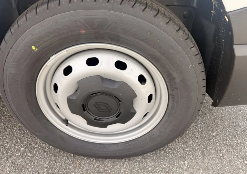 Gros plan sur la roue avant droite du Renault Trafic Fourgon blanc avec jante acier et logo Renault central.