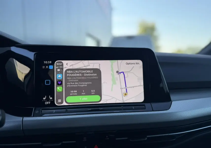 Écran tactile central de la Volkswagen Golf 8 blanche affichant la navigation GPS avec interface smartphone connectée.