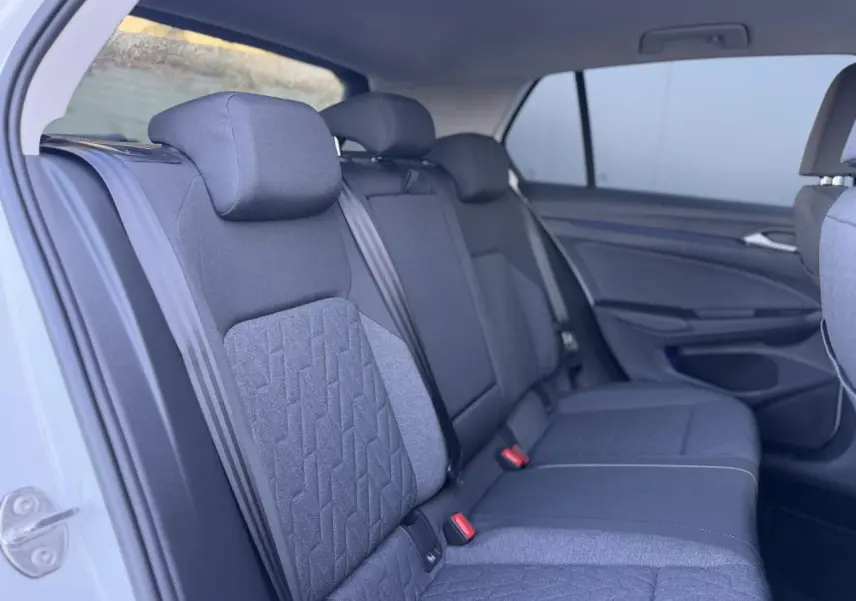 Vue intérieure côté gauche des sièges arrière en tissu gris de la Volkswagen Golf 8 blanche.