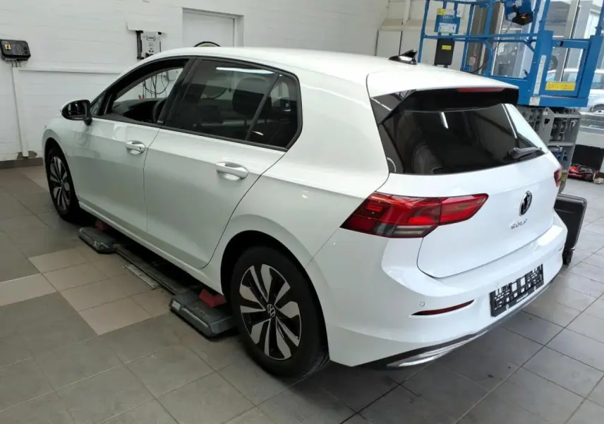 Vue 3/4 arrière droite d'une Volkswagen Golf 8 blanche Pure avec feux arrière LED et jantes alliage Norfolk.