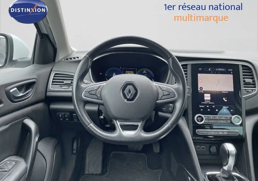 Vue intérieure centrée sur le volant et la console tactile d'une Renault Mégane Break blanche Glacier, finition Intens 2021.