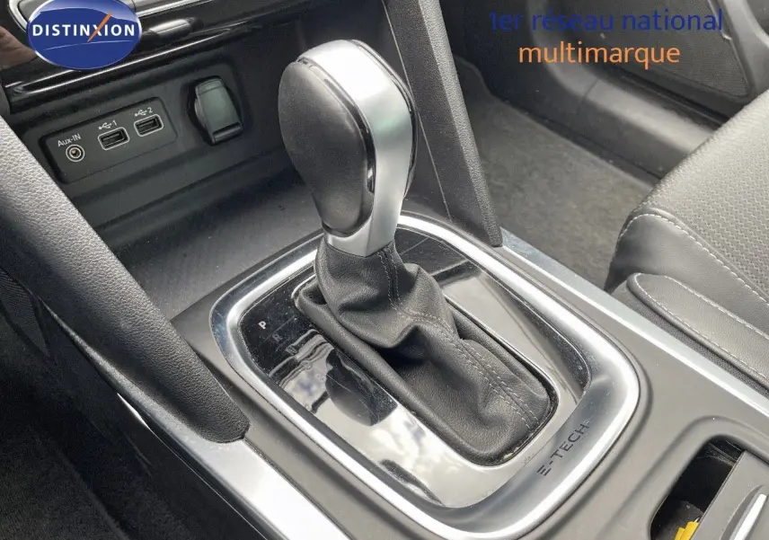Le levier de vitesse automatique en gros plan dans l’habitacle de la Renault Mégane Break hybride blanche.