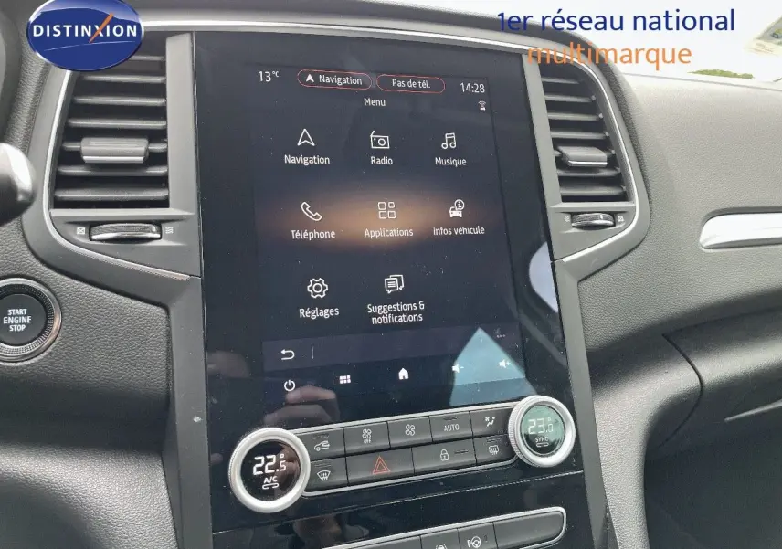 Vue intérieure centrée sur l'écran tactile et la console centrale du Renault Megane Break blanc Glacier 2021.