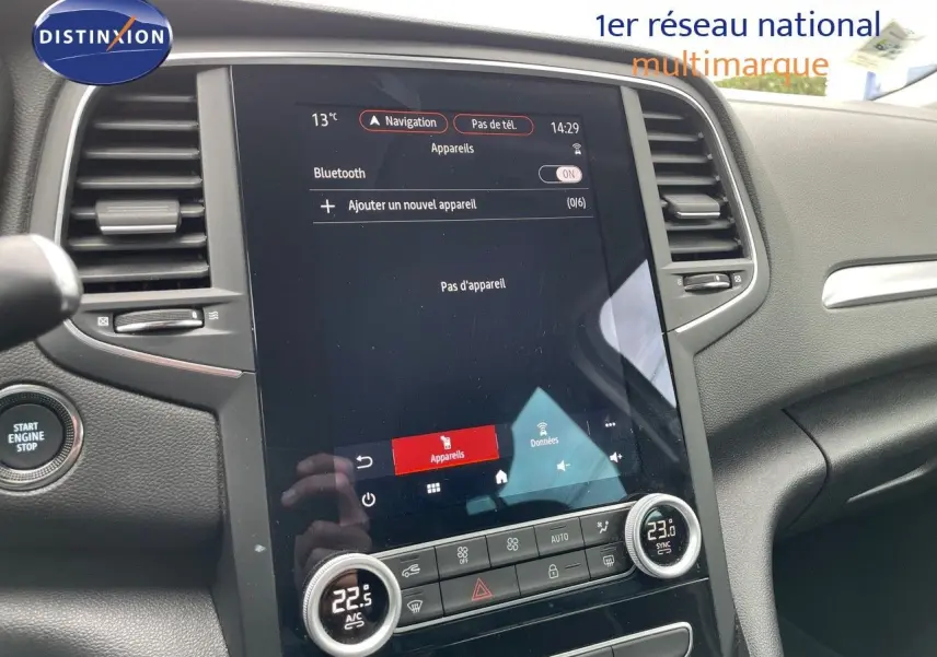 Vue intérieure centrée sur l’écran tactile et la console centrale du Renault Mégane Break blanc glacier, version 2021.