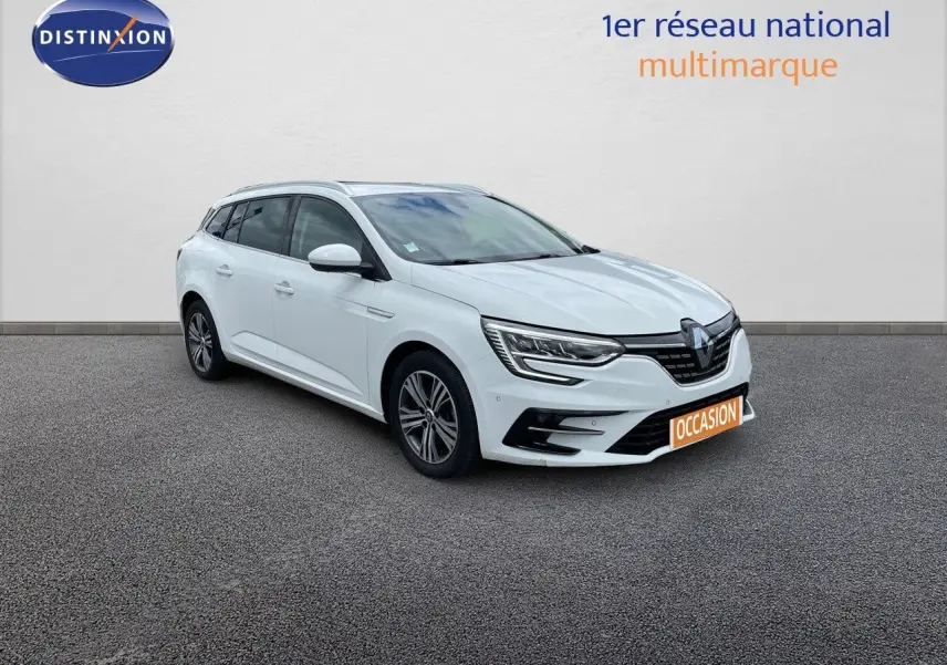 Renault Mégane Break blanc glacier vue 3/4 avant droit, avec phares LED et calandre noire distinctive.