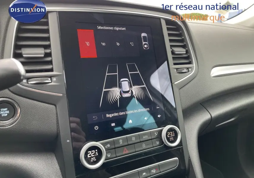 Vue rapprochée de la console centrale avec écran tactile et commandes de climatisation du Renault Megane Break blanc Glacier 2021.